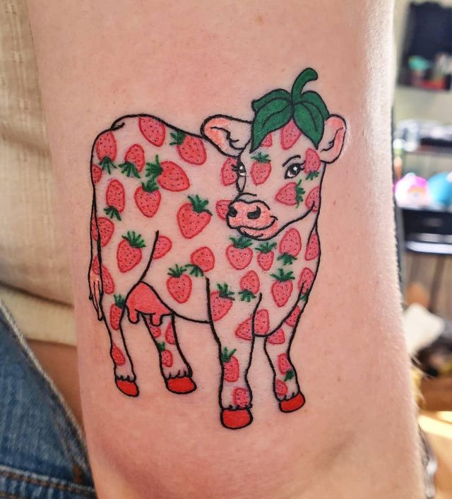 Elegant Strawberry Cow Tattoo on Upper Arm