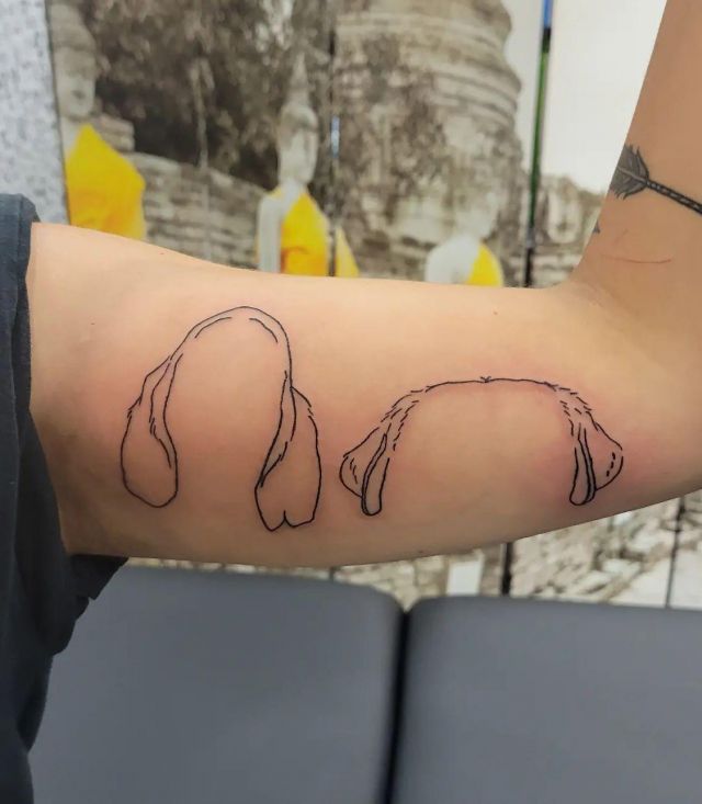 Two Dog Ear Tattoo on Upper Arm