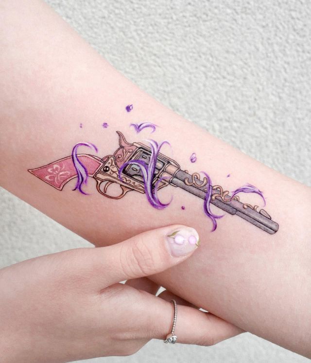 Elegant Revolver Tattoo on Upper Arm